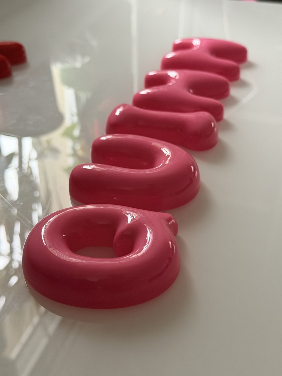 Close-up of glossy wine-coloured bubble letters